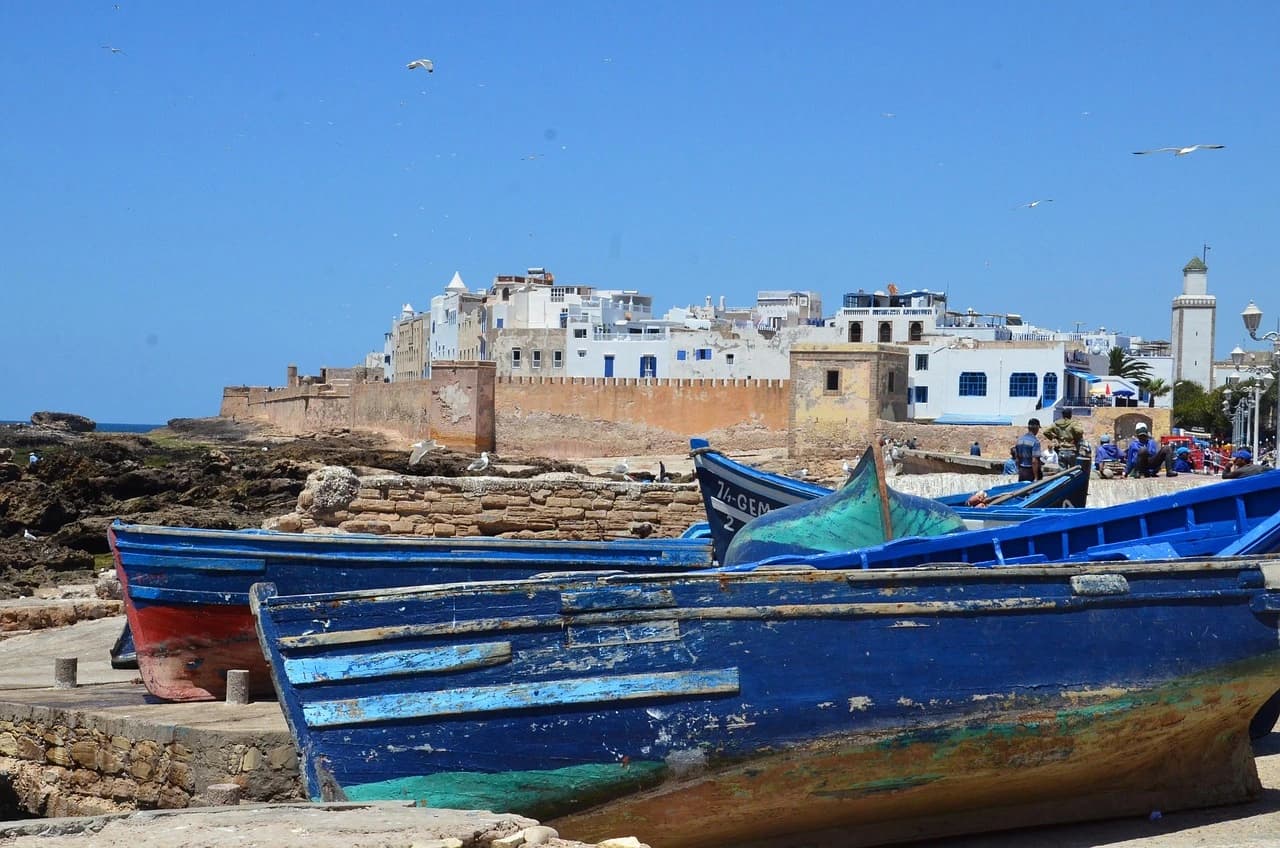 Vue panoramique d'Essaouira : remparts blancs, port de pêche et Atlantique au coucher du soleil